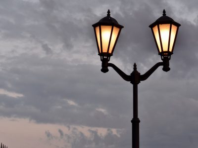 street lamp with lamps on against a background of dark clouds at dusk. embankment of the Gulf of Finland Strelnya Russia